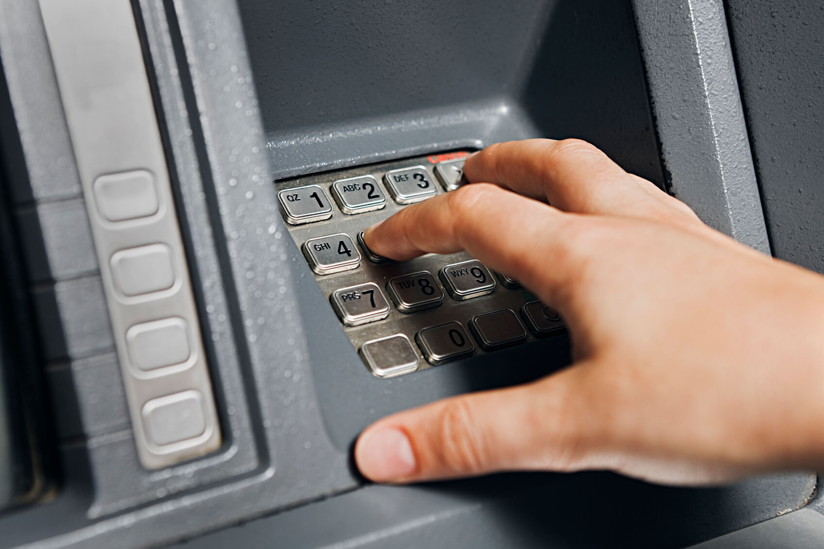 Close up on a woman's hand as she enters numbers on an ATM keypad. Shot with Canon EOS 1Ds Mark III.