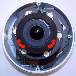 A dome IP camera sensor with arrows showing how to adjust the sensor in a clockwise position during IP camera set up