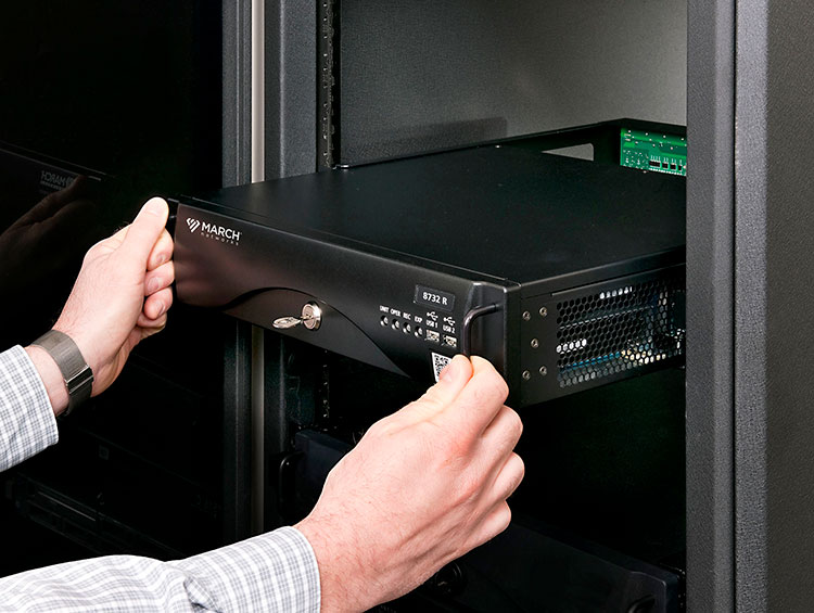 a person inserts a March Networks network video recorder into a docking station