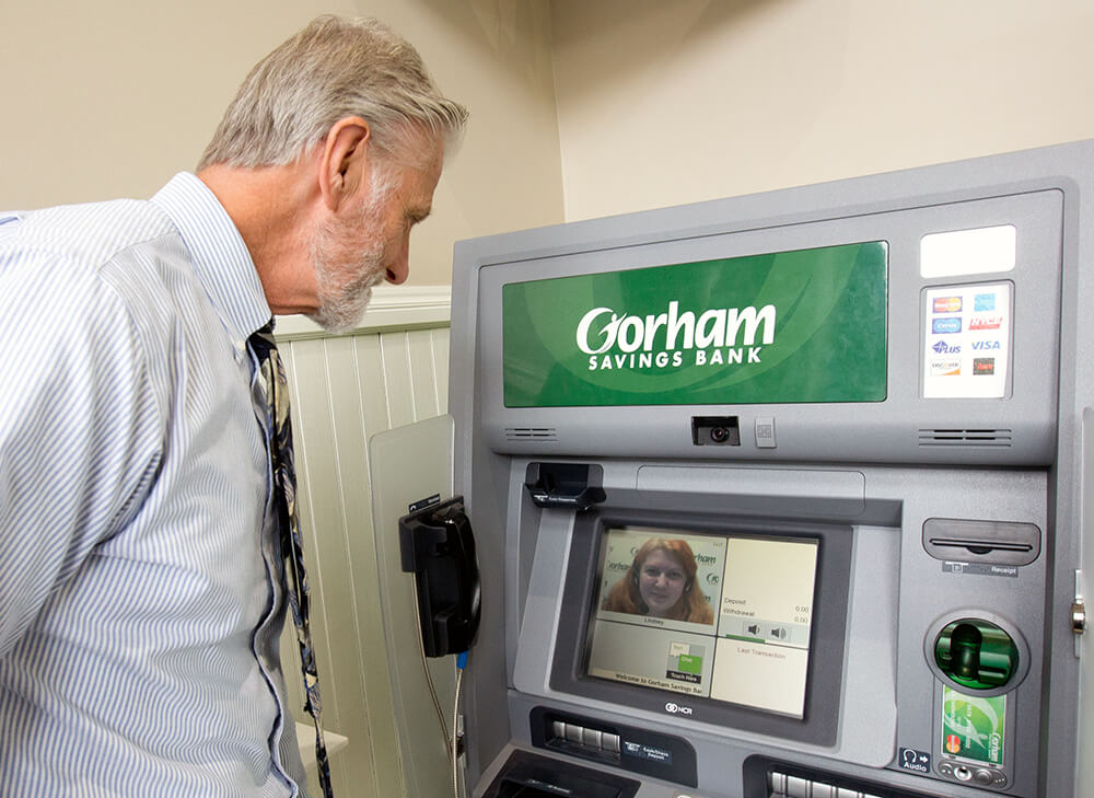 a man stands in front of a Gorham Savings Bank Interactive Teller Machine (ITM). Gorham Savings Bank is using March Networks video surveillance at its ITMs.