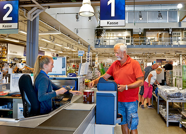 a man stands at a cash register inside a Carlsen Fritzoe location