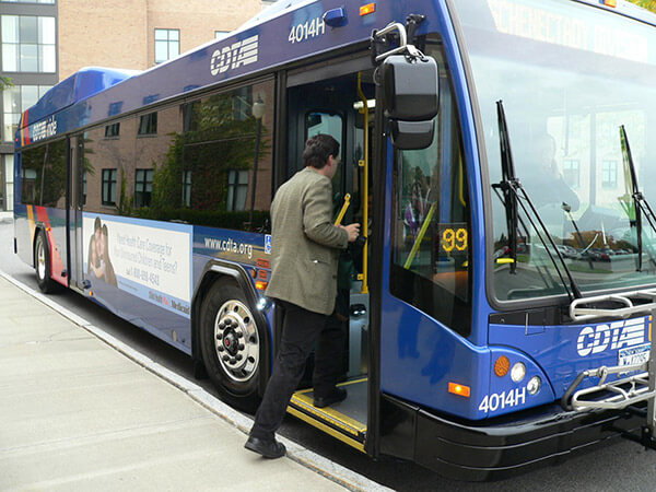 a man boards a bus belonging to the Capital District Transportation Authority