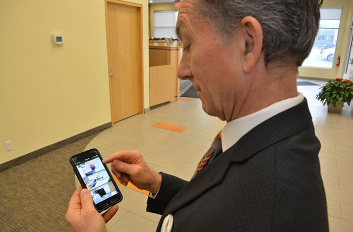 Tom Dimson, CEO of Equity Credit Union, looks at his surveillance images on his phone