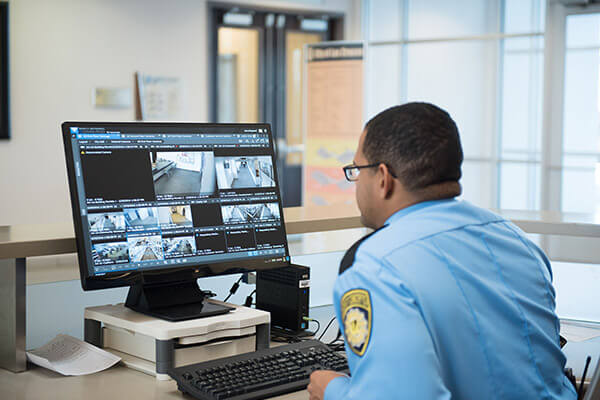 a security officer looks at surveillance video on a computer monitor