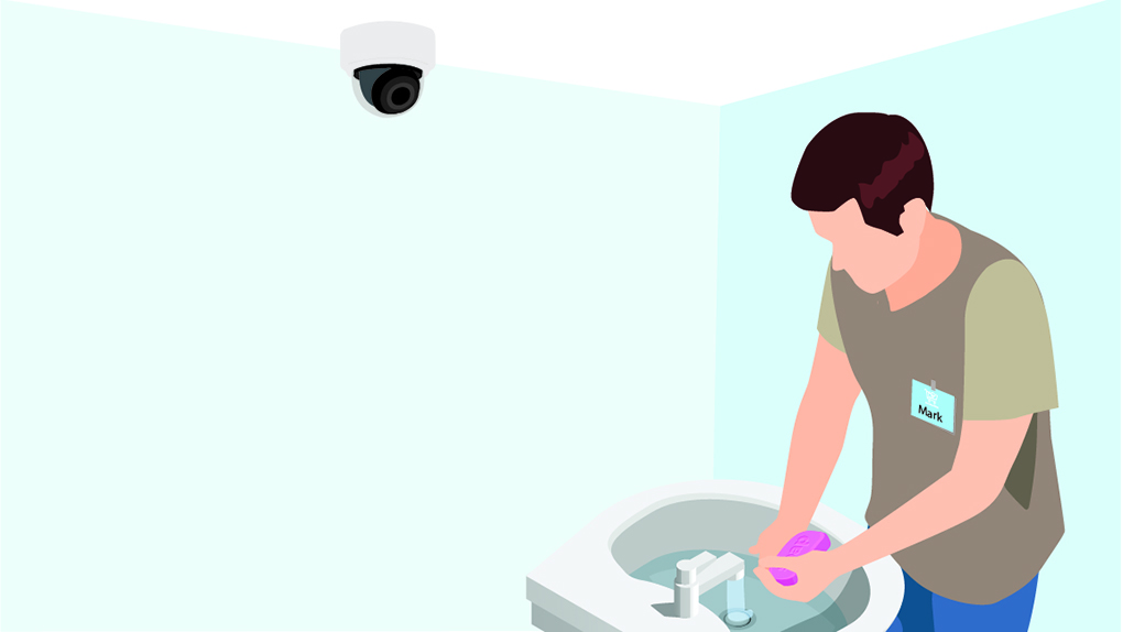 Man washing his hands with dome camera overhead.