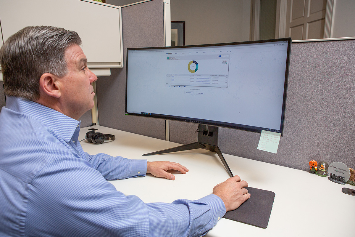 Don Maday, General Manager for Cox Family Stores, using Insight Monitoring and Resolution Service on a desktop computer in an office